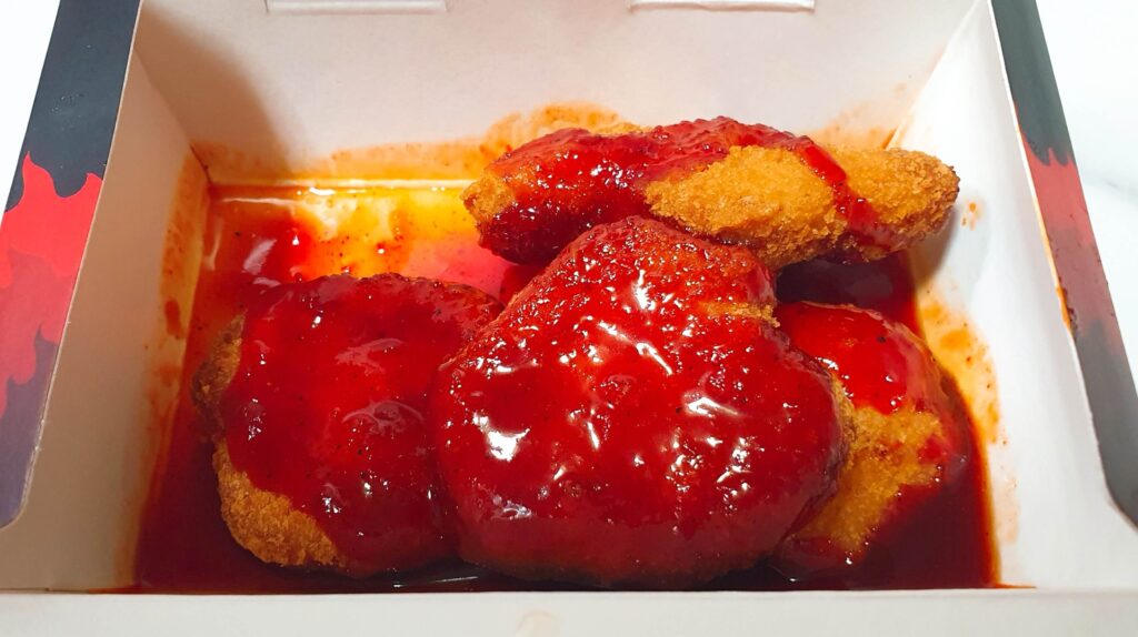 롯데리아 디지게 매운 돈까스 중 달콤하고 평범한 빨간색 소스가 발려진 양념맛 패티의 모습 - 압박감이 느껴지지 않는 익숙한 비주얼을 보여주는 한끼도감 리뷰 사진