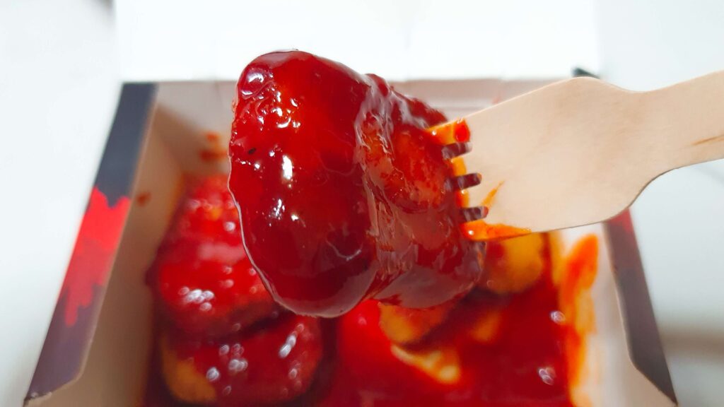 롯데리아 디지게 매운 돈까스 양념맛의 소스 광택과 패티 질감 - 돈까스보다는 치킨 너겟에 가까운 식감과 대중적인 달콤한 향을 확인할 수 있는 한끼도감 리뷰 사진