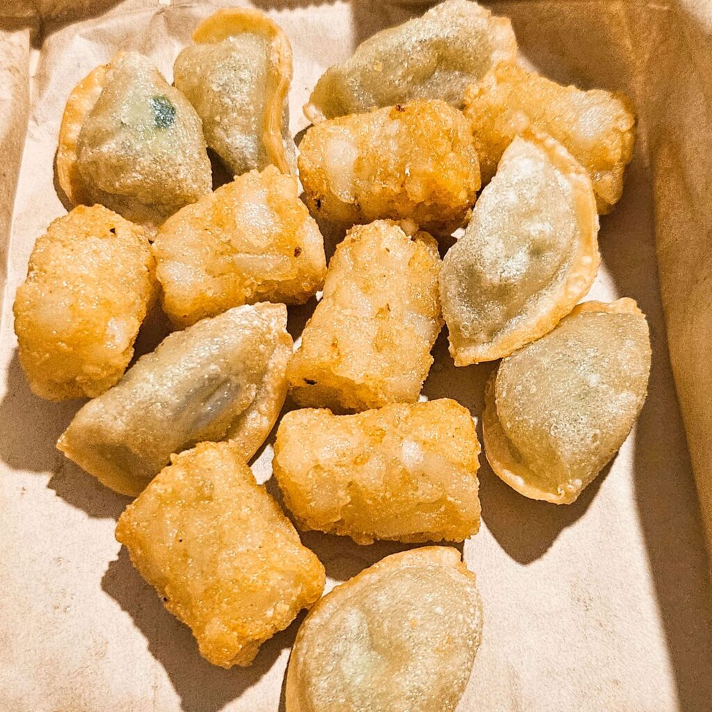 천년닭강정 주문 시 서비스로 제공되는 튀김만두와 감자튀김의 푸짐한 양을 보여주며 가성비를 증명하는 사진.